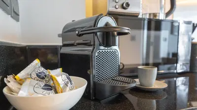 a kitchen counter with a sink with a mixer and a bowl at Bright Deluxe Studio canal view - Special offer in Dubai