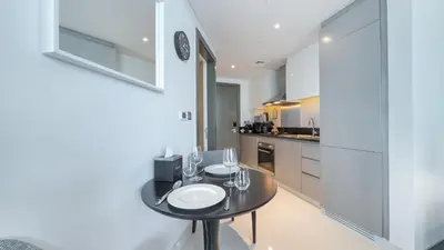 a kitchen with a table with wine glasses on it at Bright Deluxe Studio canal view - Special offer in Dubai