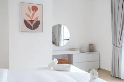 a white bedroom with a bed and a mirror at Dominant View of Dubai Marina in Dubai