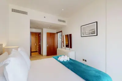 a bedroom with a white bed with white pillows at Marina Gate 1, Dubai Marina - Chic One Bedroom in Dubai
