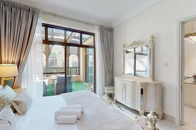 a white bedroom with a large bed and a large window at Al Tajer, Core C, Souk Al Bahar - Charming Two Bedroom in Dubai