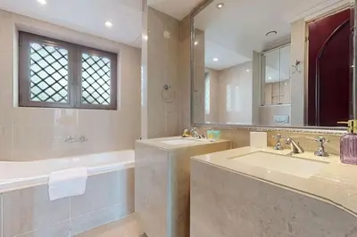 a bathroom with two sinks and a tub and a mirror at Al Tajer, Core C, Souk Al Bahar - Charming Two Bedroom in Dubai