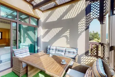 a patio with a wooden table and chairs at Al Tajer, Core C, Souk Al Bahar - Charming Two Bedroom in Dubai