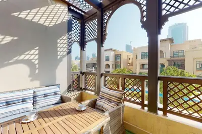 a porch with a wooden bench on a balcony at Al Tajer, Core C, Souk Al Bahar - Charming Two Bedroom in Dubai