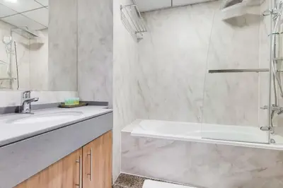 a bathroom with a shower and a sink and a tub at Bay Central, Dubai Marina - Exquisite One Bed with Marina View in Dubai