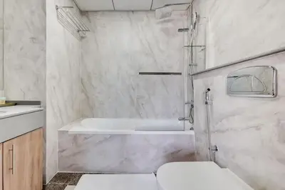 a bathroom with a tub and a toilet and a sink at Bay Central, Dubai Marina - Exquisite One Bed with Marina View in Dubai