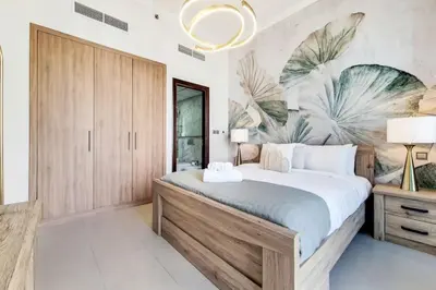 a bedroom with a large bed and a mural of palm trees at Bay Central, Dubai Marina - Exquisite One Bed with Marina View in Dubai