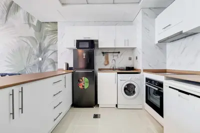 a kitchen with a refrigerator and a washer and dryer at Bay Central, Dubai Marina - Exquisite One Bed with Marina View in Dubai