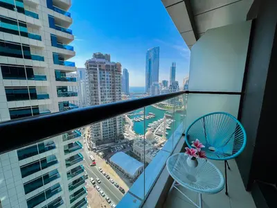 a balcony with two chairs and a view of a city at Charming 1BR Apart With Stunning Sea&Marina Views in Dubai
