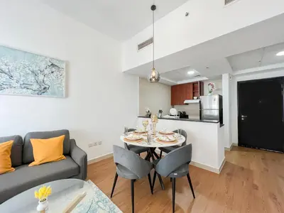 a kitchen and a living room with a table and a couch at Charming 1BR Apart With Stunning Sea&Marina Views in Dubai
