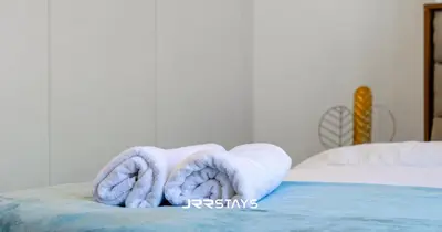 a pile of towels sitting on top of a bed at Stylish Studio - Panoramic Pool View - JVC in Dubai