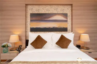 a bedroom with a large white bed with two lamps at Suitestay Address Dubai Mall Residence in Dubai