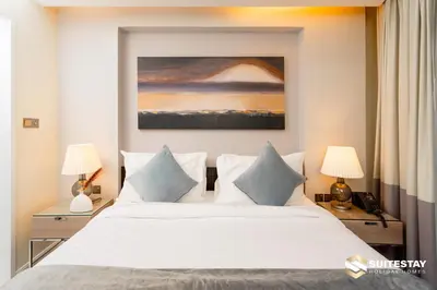 a bedroom with a large white bed with two lamps at Suitestay Address Dubai Mall Residence in Dubai