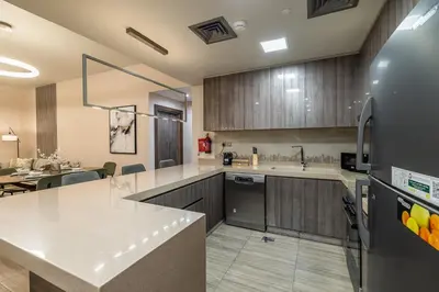 a large kitchen with a counter and a refrigerator at MBL I Modern 2 Bedroom Apartment in JLT in Dubai