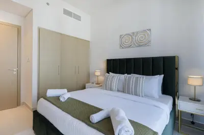 a bedroom with a large white bed with towels on it at Elegant 2 Bedroom Luxury Living in Harbour Gate - Allsopp&Allsopp in Dubai