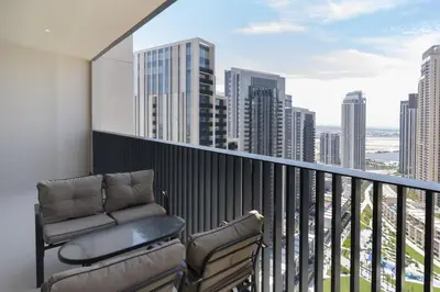 a balcony with a chair and a view of the city at Elegant 2 Bedroom Luxury Living in Harbour Gate - Allsopp&Allsopp in Dubai