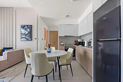 a kitchen and dining room with a table and chairs at Silkhaus Burj Royale 1BDR with balcony in Downtown in Dubai