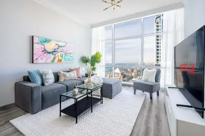 a living room with a couch and a large window at GuestReady - Lux interiors in Dubai Marina in Dubai