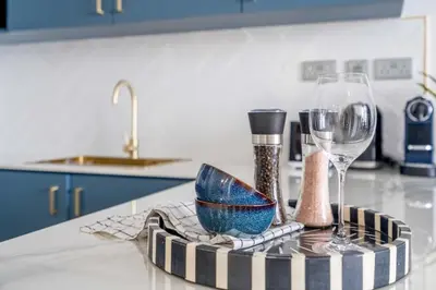 a kitchen counter with a table with a wine glass at GuestReady - Lux interiors in Dubai Marina in Dubai