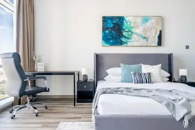 a bedroom with a bed and a desk and a chair at GuestReady - Lux interiors in Dubai Marina in Dubai
