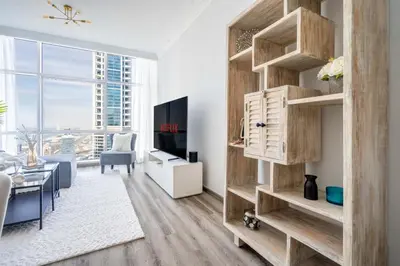 a living room with wooden shelves and a tv at GuestReady - Lux interiors in Dubai Marina in Dubai