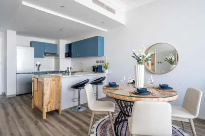a kitchen and dining room with a table and a mirror at GuestReady - Lux interiors in Dubai Marina in Dubai