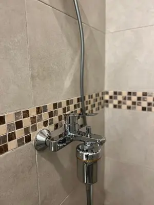 a shower with a silver faucet in a bathroom at Athesa Apartments Downtown Dubai Business Bay in Dubai