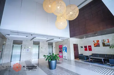 a lobby with a potted plant and two lights at Alashrafia Saray - Adorable 1BR in Sports City in Dubai