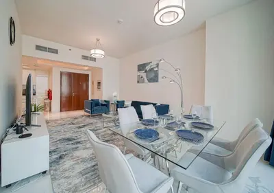 a dining room with a glass table and white chairs at The stylish Meera tower 3606 apartment in Al Habtoor city in Dubai