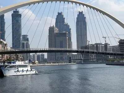 a boat in the water under a bridge at The stylish Meera tower 3606 apartment in Al Habtoor city in Dubai