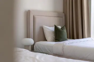 a bedroom with a bed with a green pillow on it at TH-Homes Downtown 2 Bedroom with Burj Khalifa view in Dubai