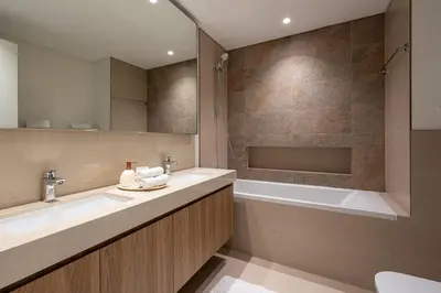 a bathroom with a sink and a tub and a mirror at TH-Homes Downtown 2 Bedroom with Burj Khalifa view in Dubai