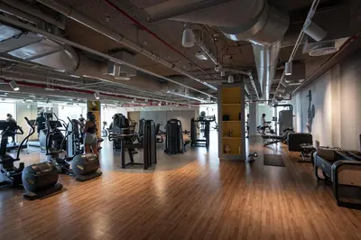a gym with tread machines and people exercising in it at TH-Homes Downtown 2 Bedroom with Burj Khalifa view in Dubai