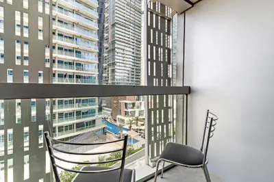a chair sitting on a balcony with a view of a city at StoneTree - Cayan Tower 2 BR - Best Location in Dubai