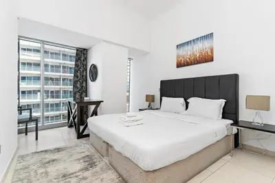 a bedroom with a large bed and a desk at StoneTree - Cayan Tower 2 BR - Best Location in Dubai