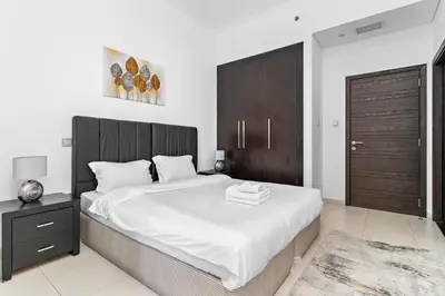 a bedroom with a large bed with a wooden headboard at StoneTree - Cayan Tower 2 BR - Best Location in Dubai