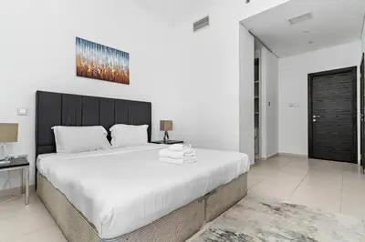 a bedroom with a large bed with a black headboard at StoneTree - Cayan Tower 2 BR - Best Location in Dubai