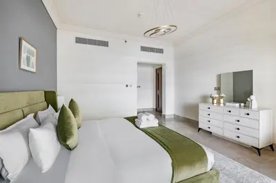 a bedroom with a large white bed and a dresser at StoneTree - Fairmont North 2 BR - Beach Access in Dubai