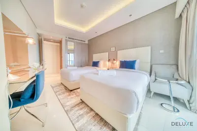 a hotel room with two beds and a desk at Sophisticated 2BR at DAMAC Towers by Paramount A Business Bay by Deluxe Holiday Homes in Dubai