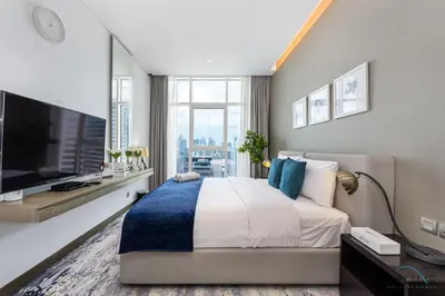 a bedroom with a large bed and a flat screen tv at Special Offer Elegant Studio with Iconic Canal Views by Deluxe Holiday Homes in Dubai