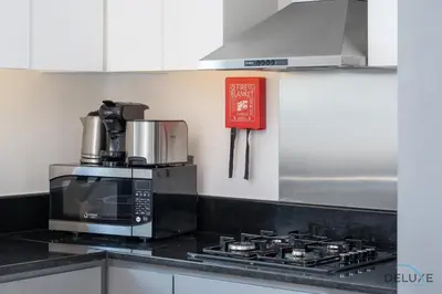 a kitchen with a microwave and a stove top oven at Special Offer Elegant Studio with Iconic Canal Views by Deluxe Holiday Homes in Dubai