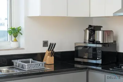 a kitchen counter with a microwave and a sink at Special Offer Elegant Studio with Iconic Canal Views by Deluxe Holiday Homes in Dubai