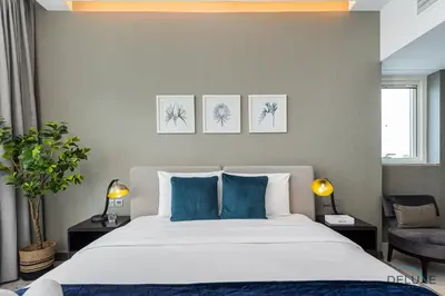 a bedroom with a large bed with blue pillows at Special Offer Elegant Studio with Iconic Canal Views by Deluxe Holiday Homes in Dubai