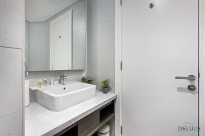 a bathroom with a white sink and a mirror at Special Offer Elegant Studio with Iconic Canal Views by Deluxe Holiday Homes in Dubai