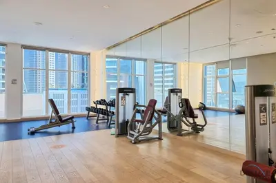 a gym with treadmills and ellipticals and mirrors at Special Offer Elegant Studio with Iconic Canal Views by Deluxe Holiday Homes in Dubai