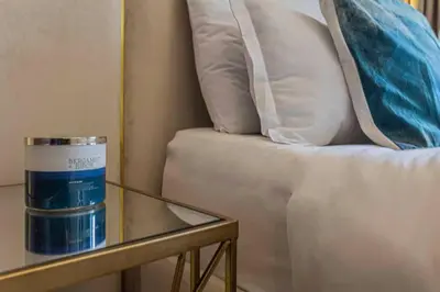 a glass table next to a couch with pillows on it at TURQUOISE - Downtown Dubai 1 BEDROOM APARTMENT Business Bay - CANAL VIEW in Dubai