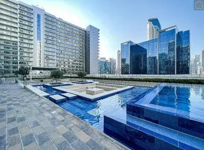 a large swimming pool in a city with tall buildings at TURQUOISE - Downtown Dubai 1 BEDROOM APARTMENT Business Bay - CANAL VIEW in Dubai