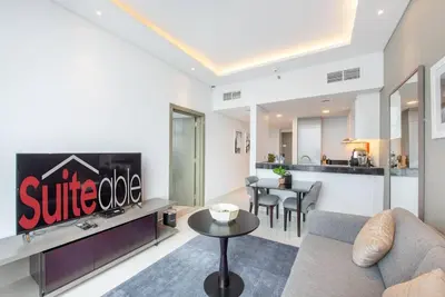 a living room with a couch and a kitchen at Upscale 1 bed apartment in Business Bay-Suiteable in Dubai