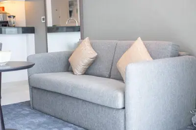 a gray couch with two pillows on it in a living room at Upscale 1 bed apartment in Business Bay-Suiteable in Dubai