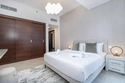 a bedroom with a large white bed and a bathroom at Lush Tropical Getaway in Dubai Marina in Dubai